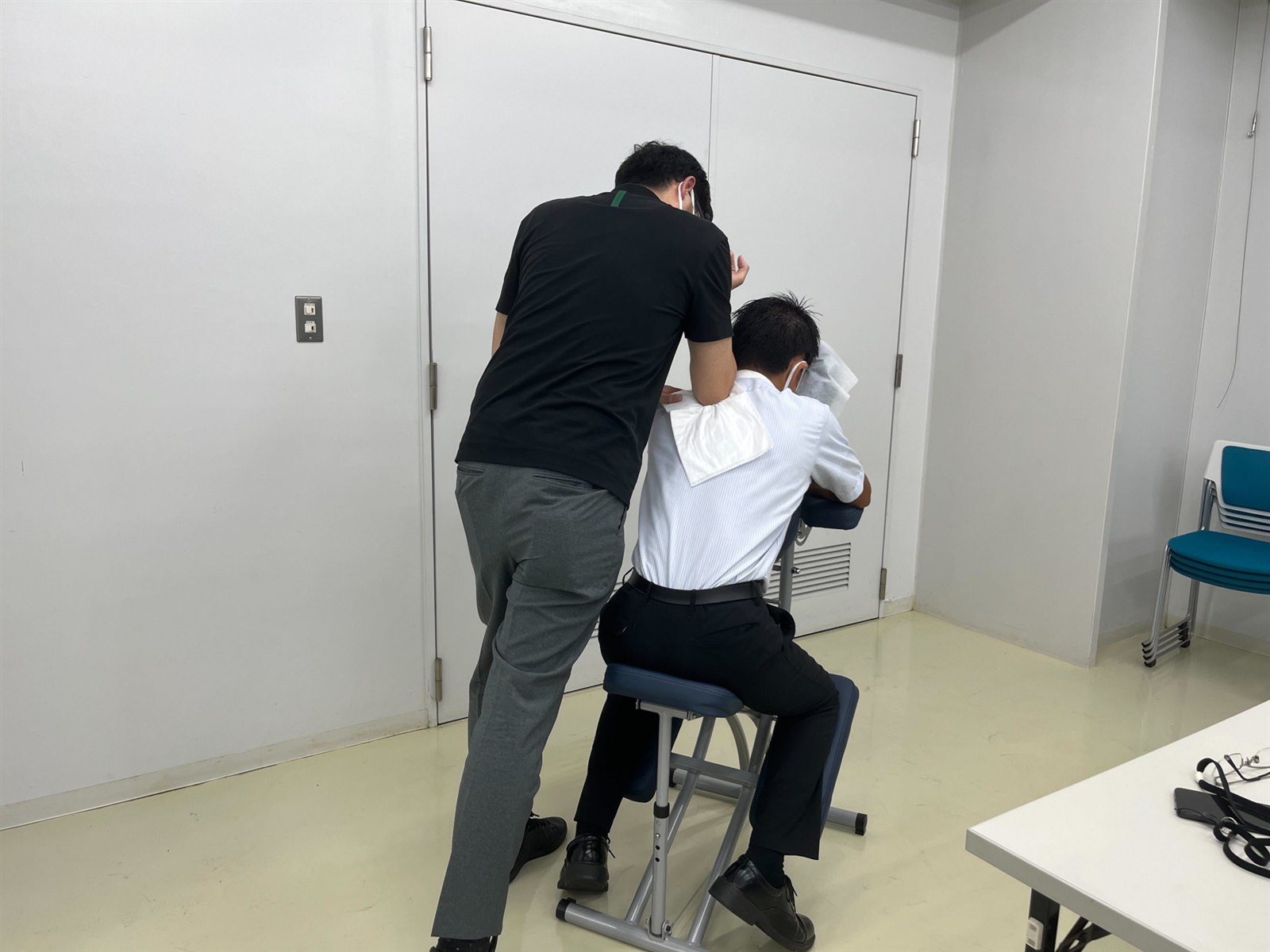 会議室の一角など省スペースで施術する様子